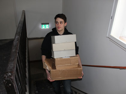 Kisten werden eine Treppe hochgetragen